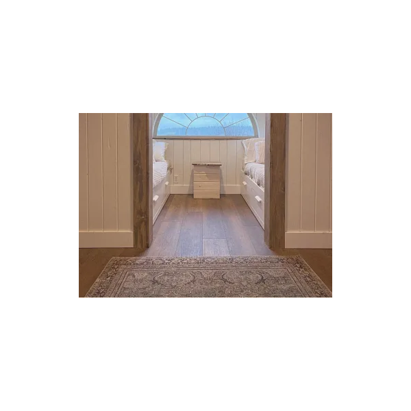 Cozy attic bedroom with wood look luxury vinyl plank flooring and arched window