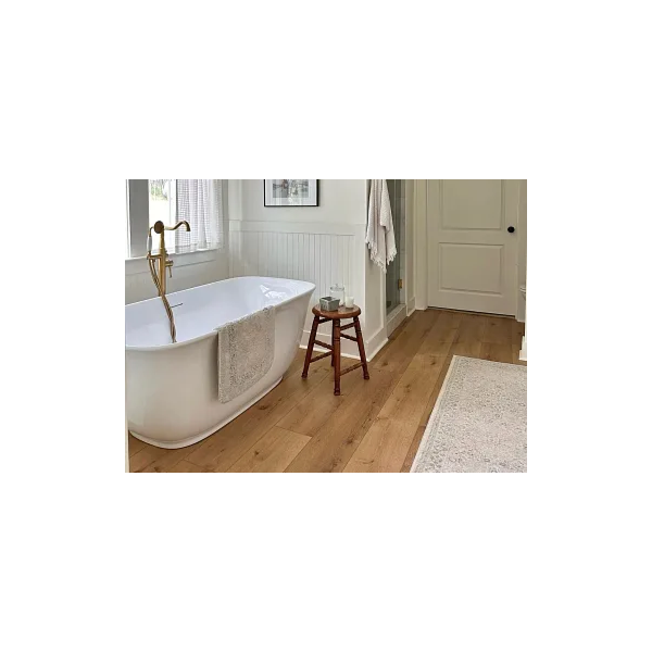 Modern bathroom with wood look luxury vinyl plank flooring, featuring a freestanding bathtub and elegant decor